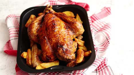 roasted chicken or turkey with potatoes in black steel mold