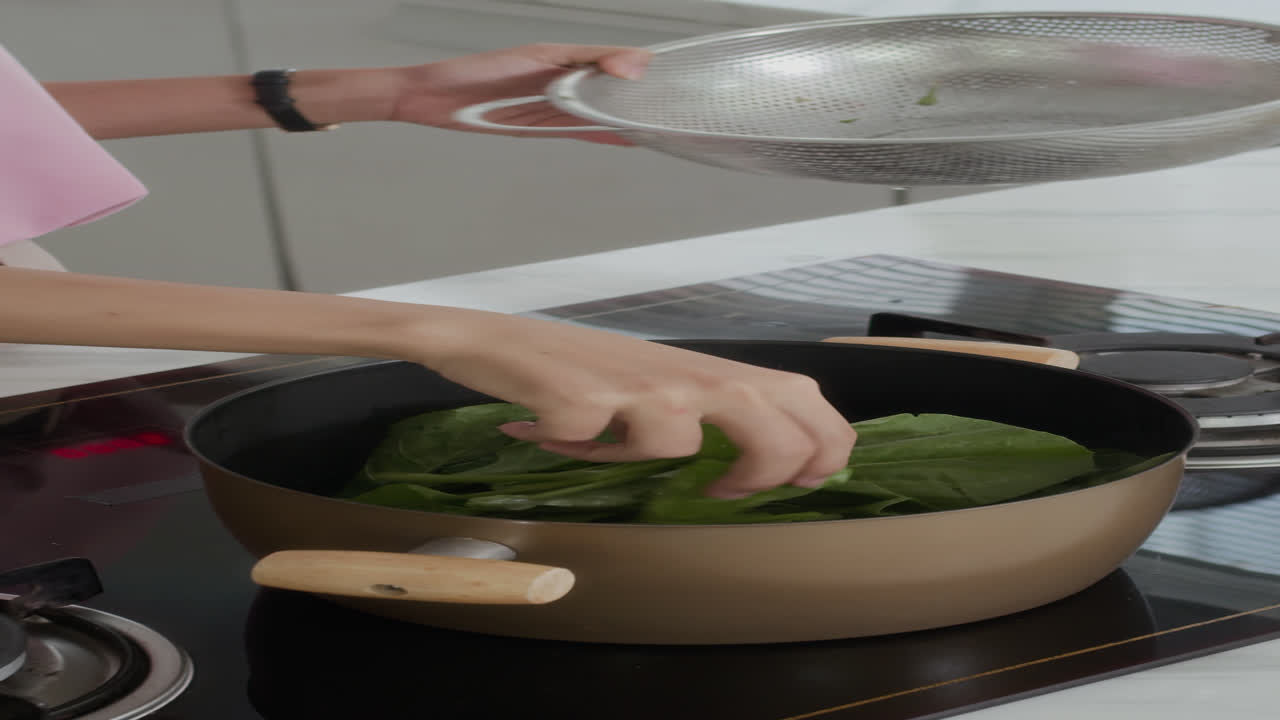 Vertical of Girl Boiling Greens for Salad at Kitchen