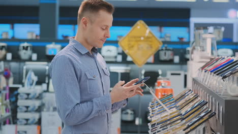 man chooses from two phones on the counter a more powerful and modern smartphone for business. buying portable devices for business