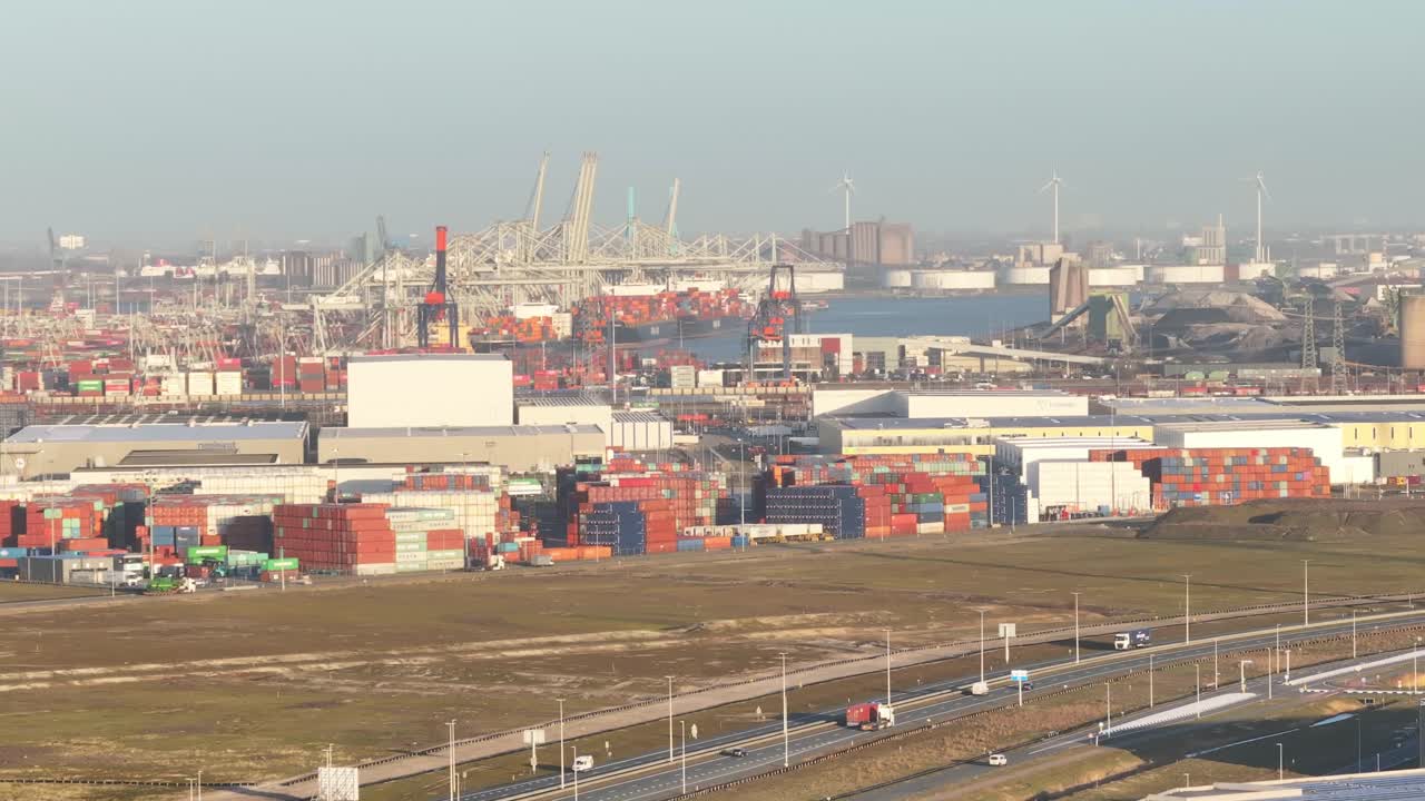 увеличенный воздушный взгляд на грузовики, движущиеся по шоссе на фоне порта роттердам