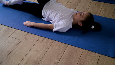 niño acostado en la alfombra de yoga