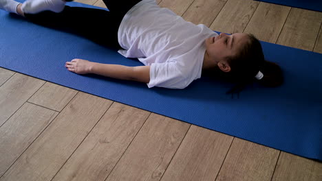 un enfant allongé sur un tapis de yoga