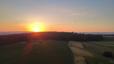 Extremely-vibrant,-orange-sunset-over-meadows-and-forests-of-Hesse,-Germany