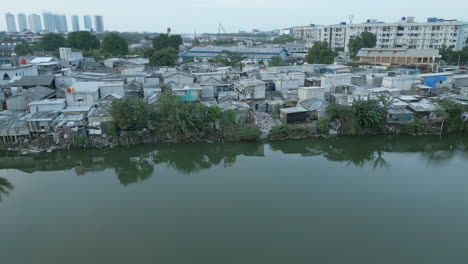 slum housing right down to the edge of pluit lake north jakarta indonesia tracking right