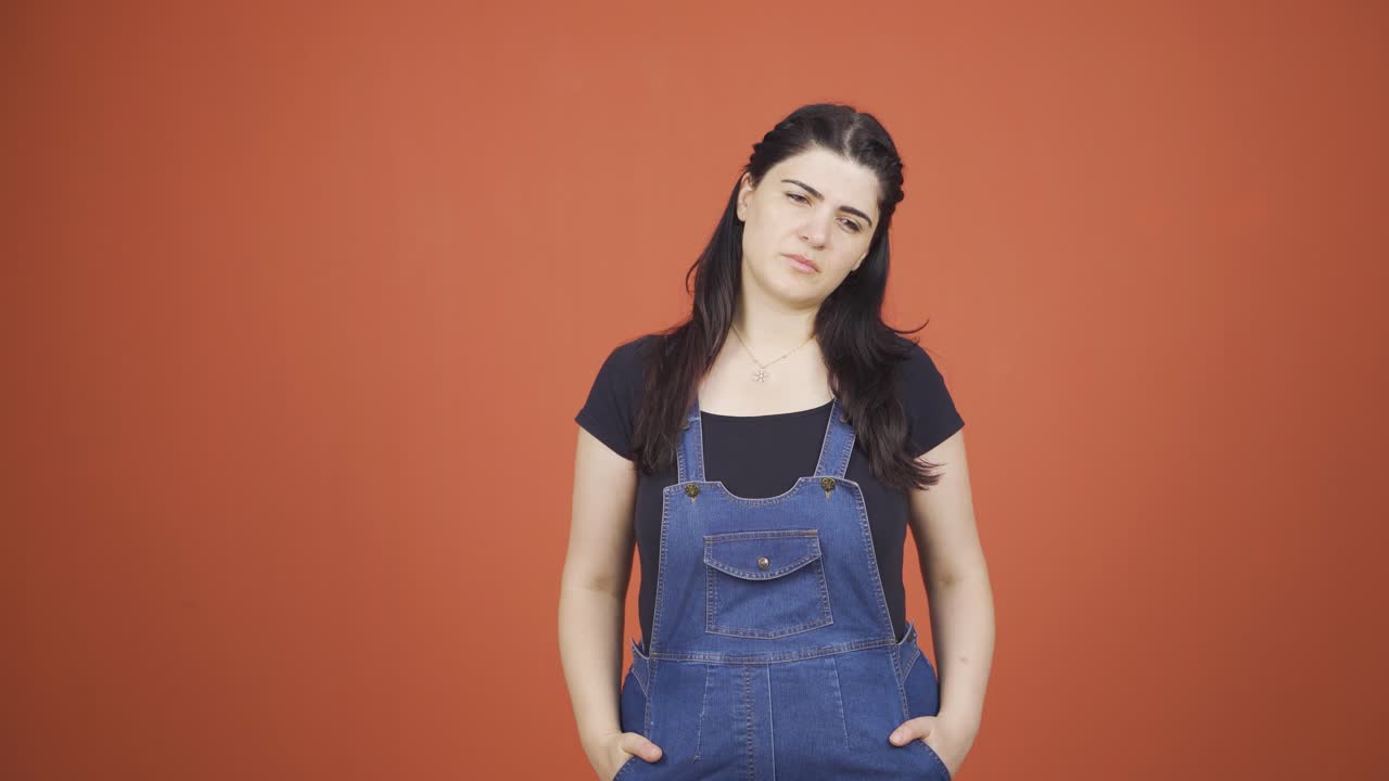 우울한 여성이 카메라를 바라보고 있습니다.