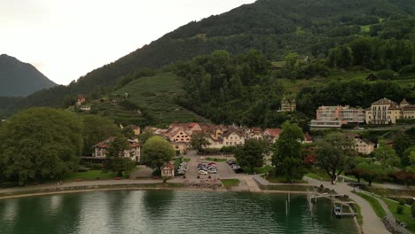 flying away from a town built under a giant mountain people live here out of the western culture simple life in the nature dock with blue and white boats houses on different heights layers of the hill