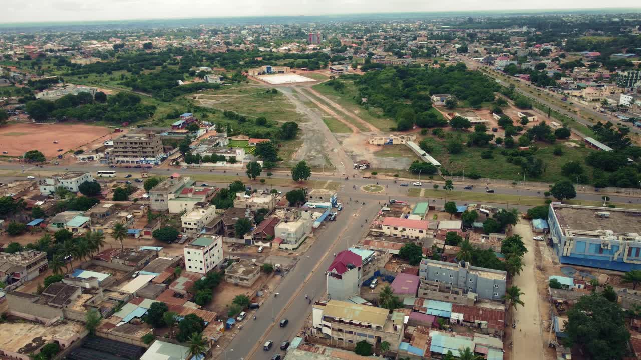 vista aérea circular cinematográfica de las carreteras de barrio de la ciudad africana con tráfico, lomé, áfrica occidental