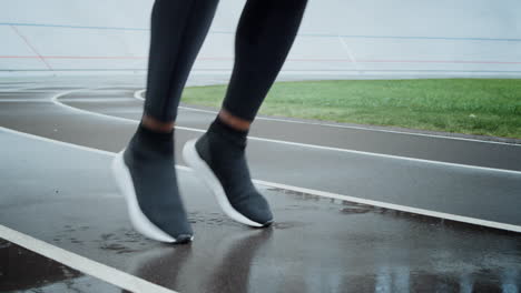 sporty man warming legs on track