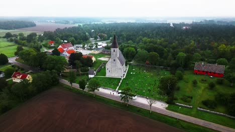 gran iglesia gris en un prado verde en la niebla, cementerio, visby, suecia, dron