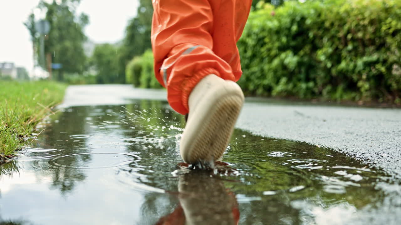 Rain puddle on gray asphalt. Large puddle with bubbles from rain. Unevenness of the asphalt surface in which water collects. Defect of the asphalt road