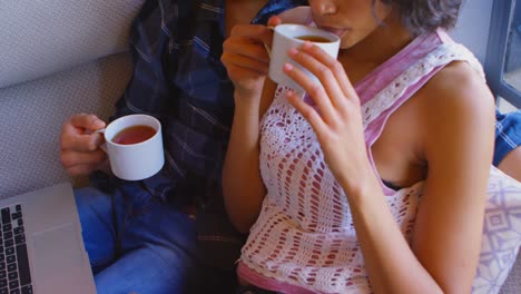 Couple-having-coffee-on-sofa-at-home-4k