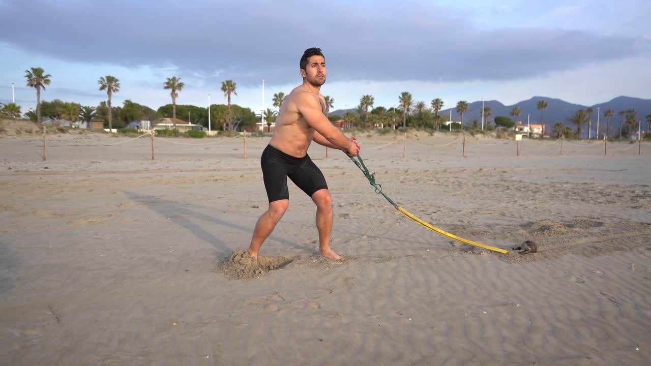 Metabolic workout on the beach with rubber dorsal variant and kettlebell