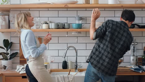 Young-couple-playing-with-soap-bubbles-in-kitchen