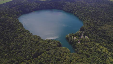 vista aérea sobre el lago eacham y su exuberante selva tropical en la meseta de atherton, queensland, australia - disparo de drones
