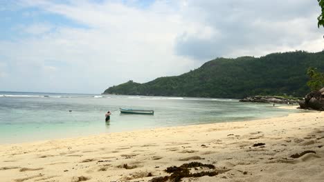 Time-lapse-of-clients-on-the-beach,-preparing-for-snorkelling,-walking-people-on-the-shore,-blue-sky,-sunny-day-and-low-tide