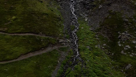 4k aerial drone footage in alaska of a waterfall stream down a mountain near palmer