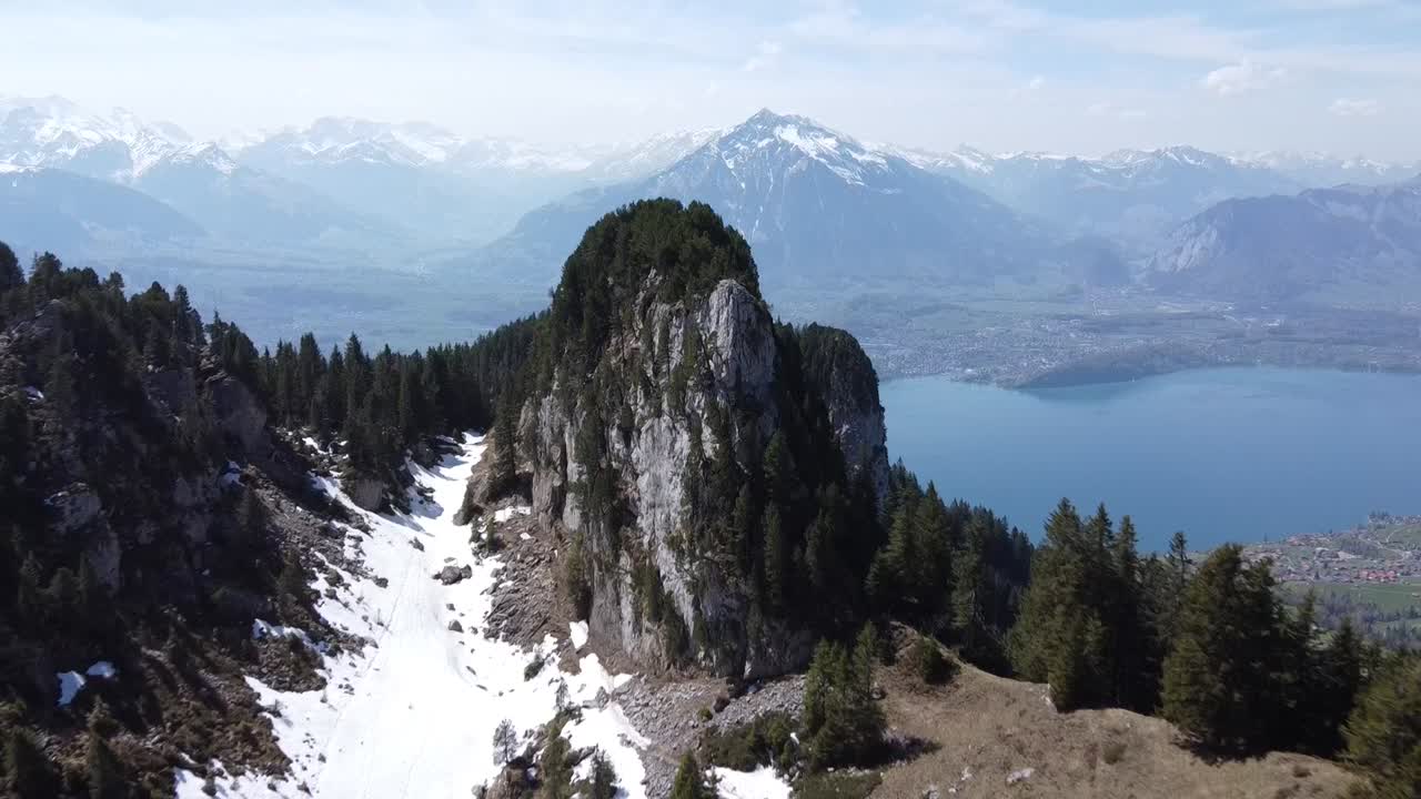 Drone view to a rock in Switzerland with a blue lake in the background