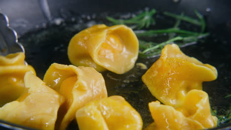 Chef-Cook-Turns-Over-Ravioli-By-Kitchen-Tongs