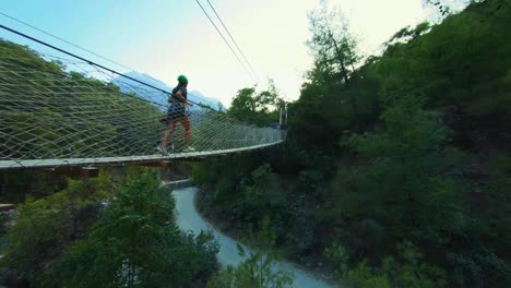 woman running on suspended pedestrian bridge over the goynuk canyon