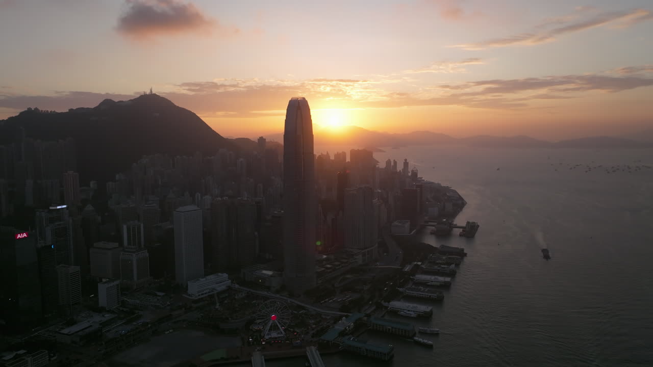 puesta de sol detrás del edificio del centro financiero internacional de hong kong, gran angular cinematográfico que establece un disparo de drones