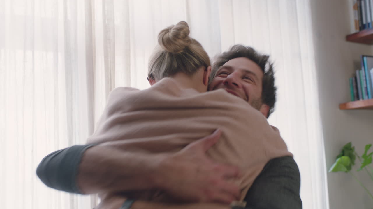 una joven pareja feliz abrazándose en casa disfrutando de un abrazo lúdico divirtiéndose celebrando la relación