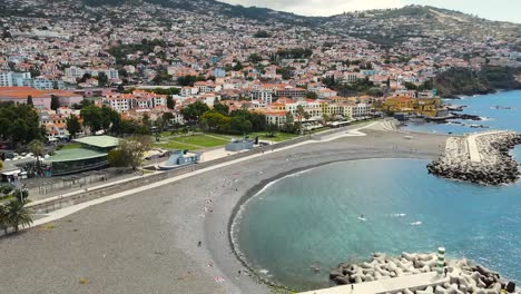 Luftschwenkaufnahme-Der-Küstenstadt-Funch-Auf-Der-Insel-Madeira,-Portugal,-Tagsüber-Umgeben-Von-Einer-Bergkette