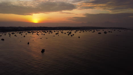 early morning near mui ne with silhouette of many fishing boats, aerial orbit shot