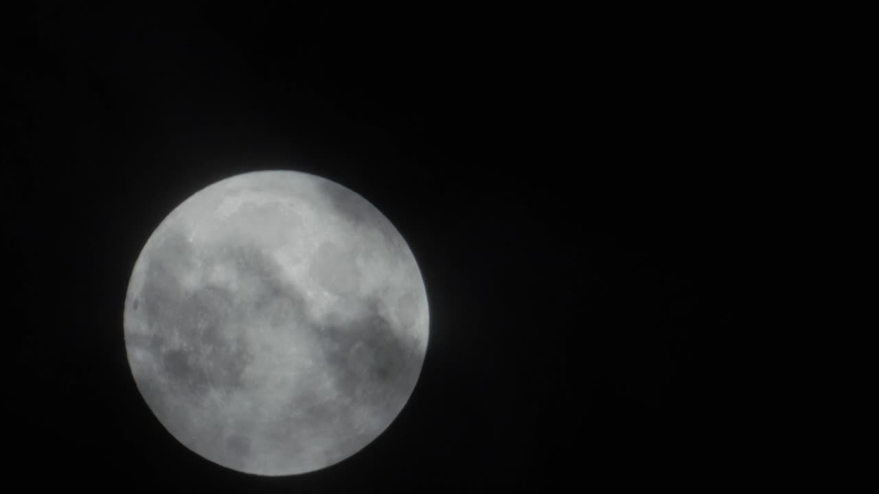 Lua cheia nasce atrás das nuvens.