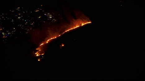 Aerial-circling-burning-mountain-vegetation-at-night