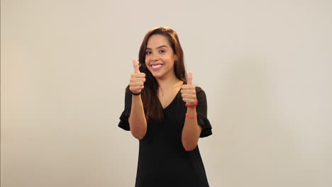 happy young woman smiling and rising thumb up