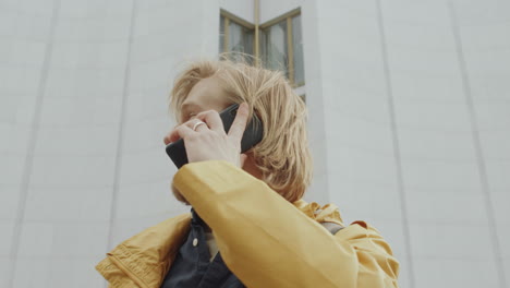 young man talking on mobile phone on street
