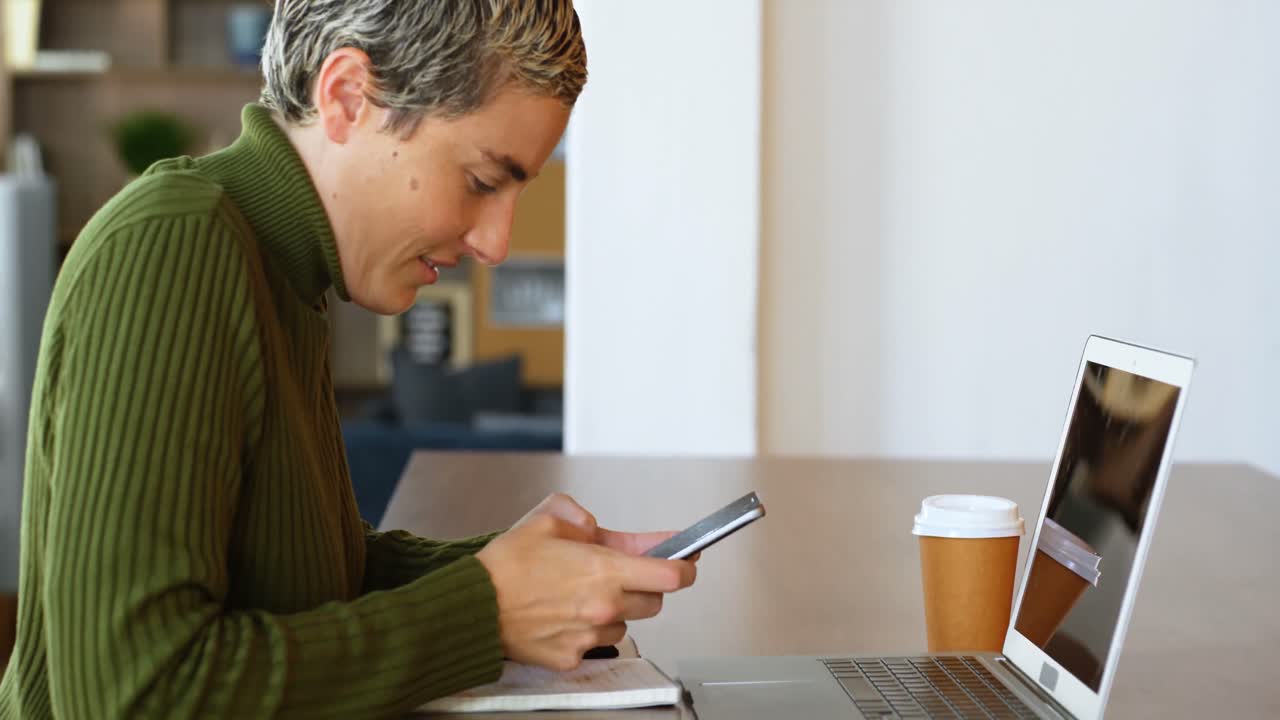 ejecutivo usando teléfono móvil en la cafetería de la oficina 4k