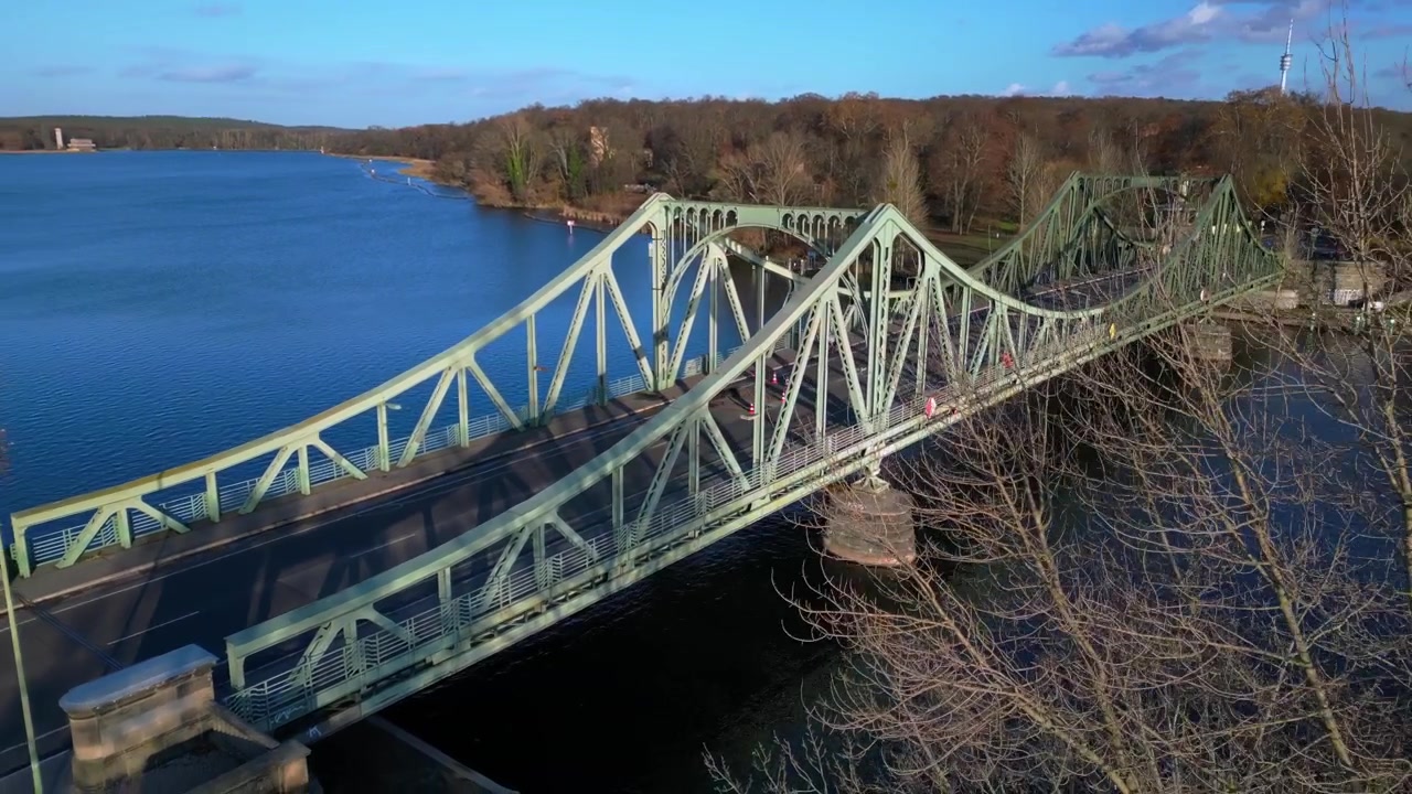 Cars crossing Glienicker Bridge over Havel river in autumn. Marvelous aerial view flight panorama orbit drone