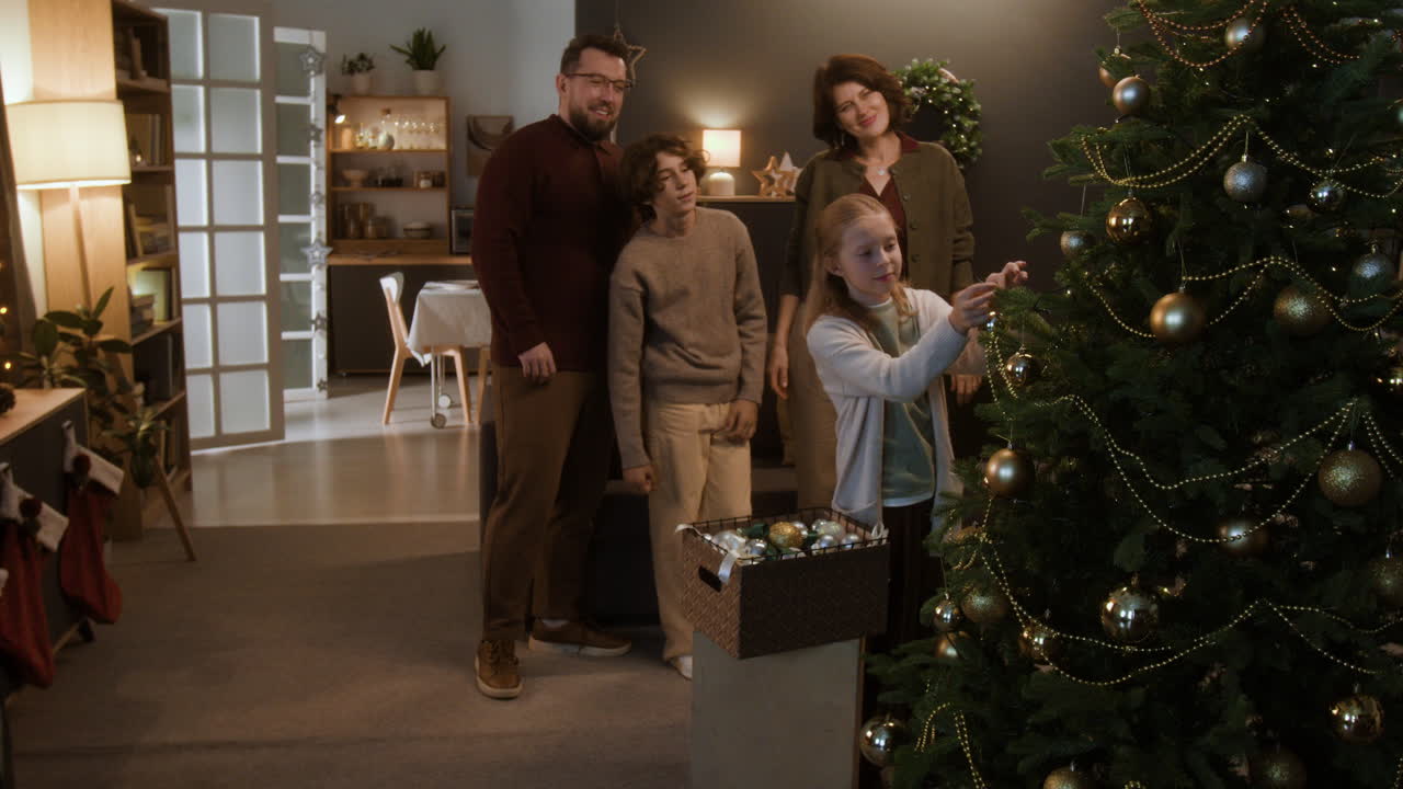 Family decorating Christmas tree at home