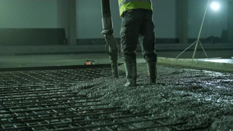 reinforced concrete. worker concretes foundation, rebar, pour cement mortar on reinforcing mesh. builders are building a factory, hangar.