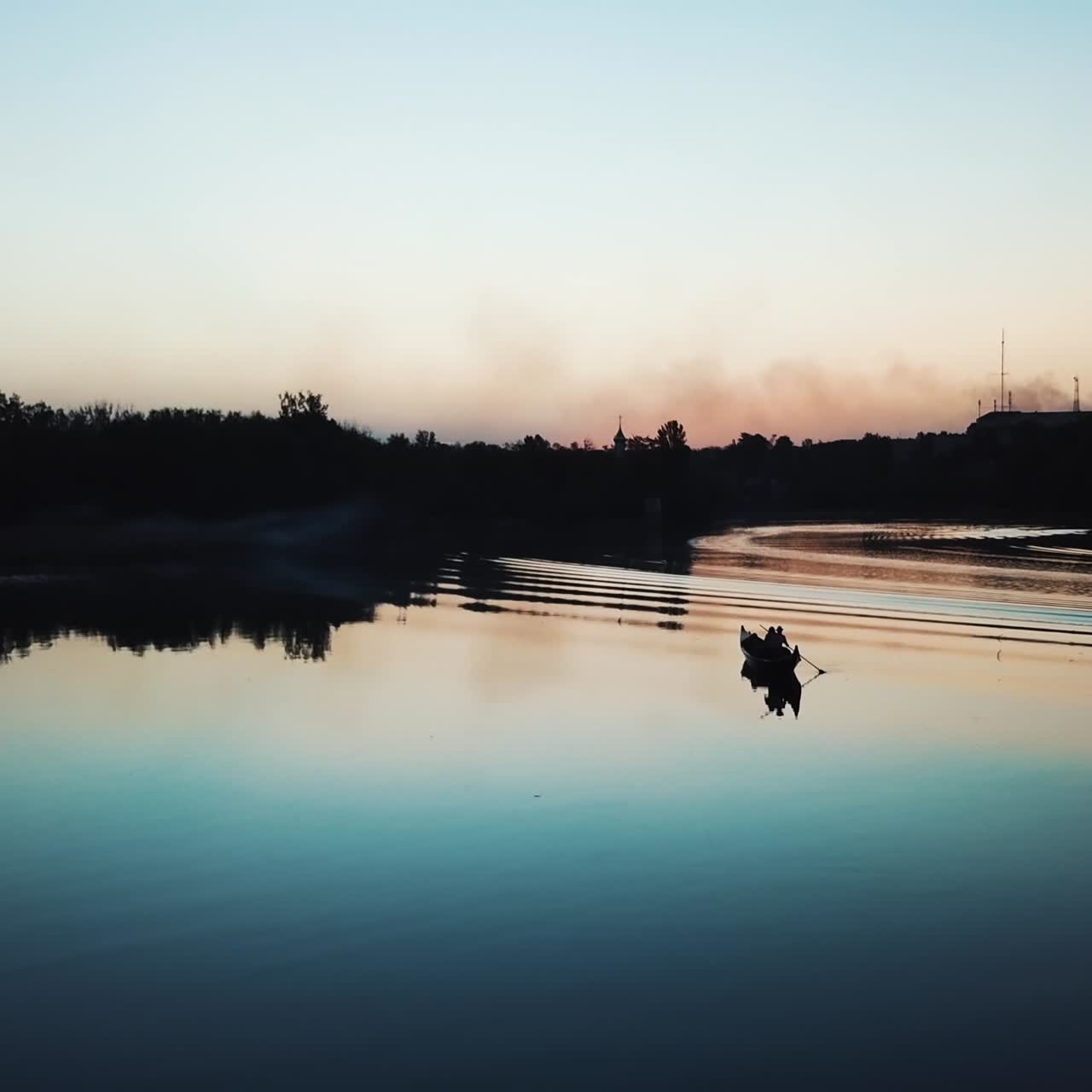 A gondolier is floating on a quiet river at sunset on a warm summer evening. Wonderful view. Slow motion. Camera motion to forward