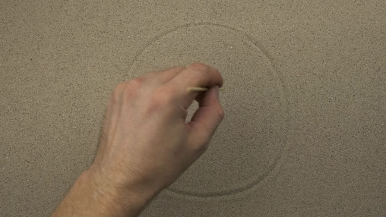 남자 손은 사람의 모래에 행복한 상징적인 얼굴을 그린다.