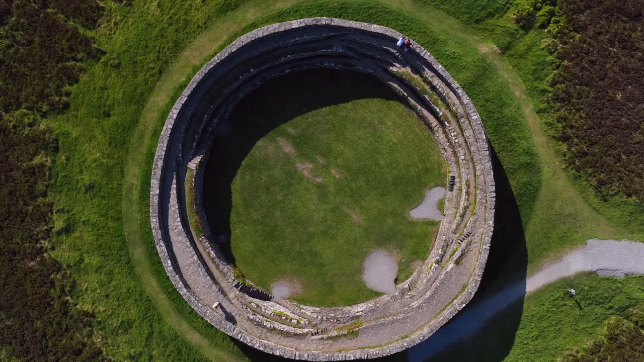 Grianan of Aileach, County Donegal, Ireland, June 2023. Drone Bird's Eye view counter clockwise descent above the spectacular stone ringfort at Inishowen surrounded by vibrant green fields.