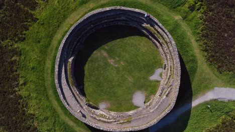 grianan of aileach, county donegal, ireland, june 2023. drone bird's eye view counter clockwise descent above the spectacular stone ringfort at inishowen surrounded by vibrant green fields.