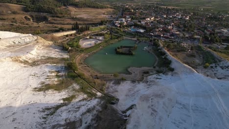 aerial view of white travertines, lake and pamukkale town, turkey, drone shot