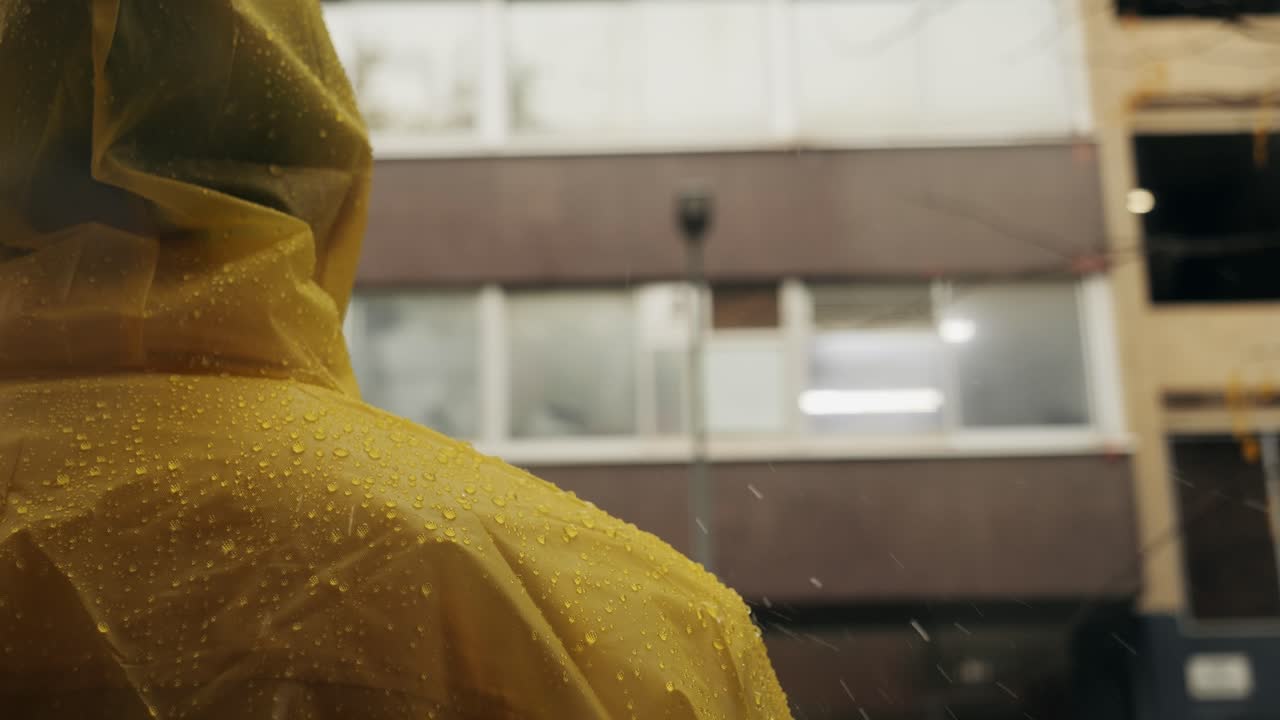 Business man tourist person with umbrella and raincoat on rainy european city street, lights reflecting, walking in Barcelona or Amsterdam during the rain
