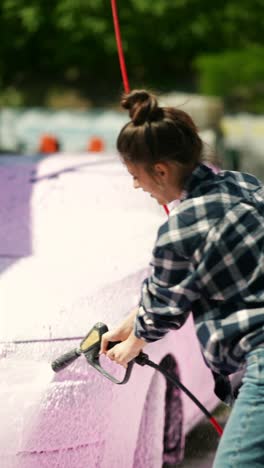 woman washing a car at a self-service car wash