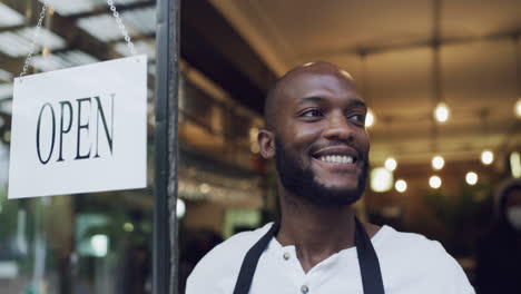 cafe owner turning open door sign at entrance to