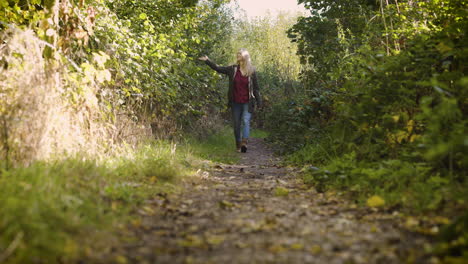 una mujer caminando por un sendero en el bosque