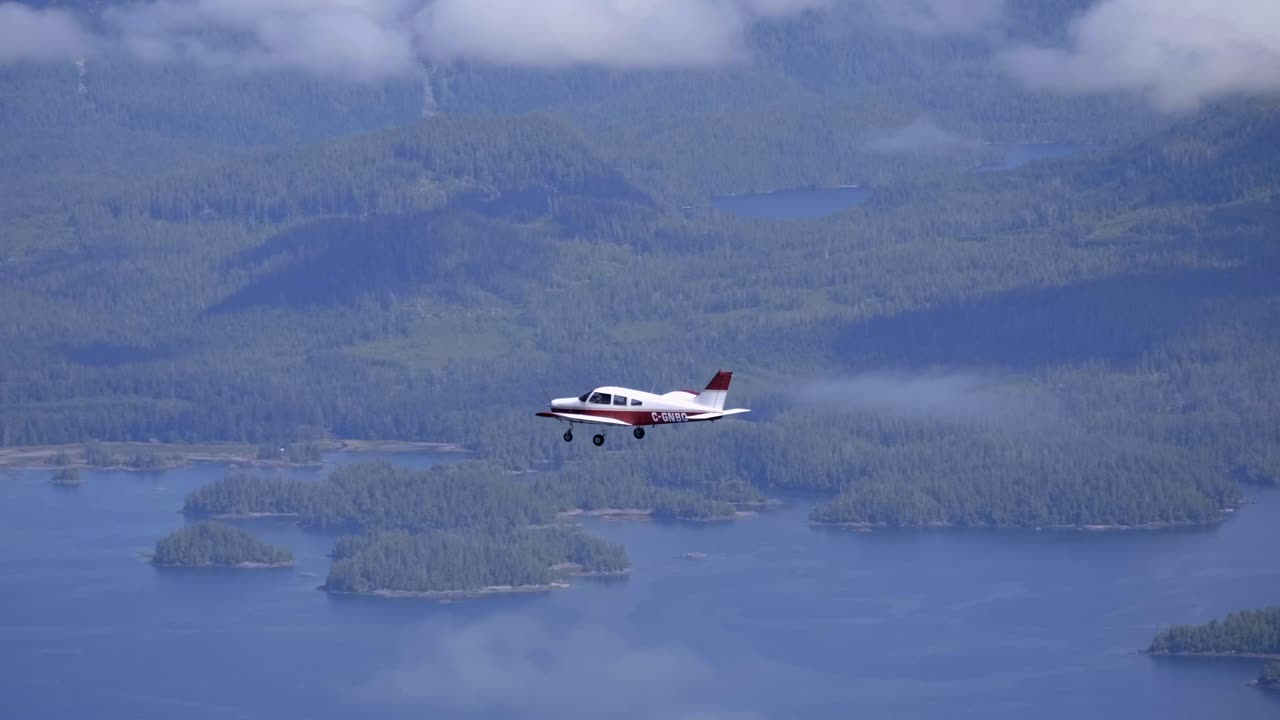 호수와 숲 위를 나는 작은 개인 비행기