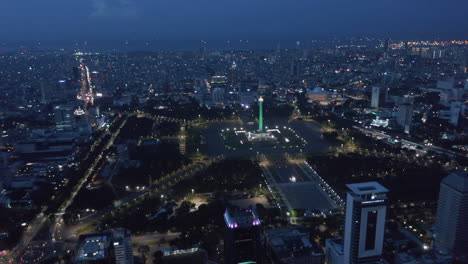 Wide-aerial-dolly-view-of-Indonesian-national-monument-Monas-symbolizing-independence-in-large-pubic-park-in-Jakarta