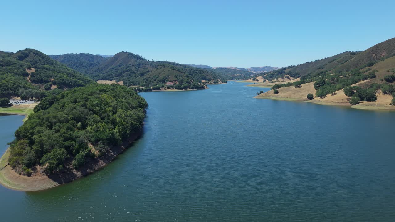 The glassy surface of Uvas Reservoir mirrors the soft hues of the sky in this quiet aerial exploration