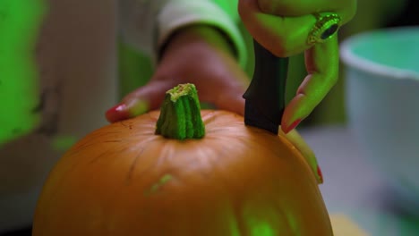 cerca de calabaza tallada en cámara lenta interior de luz verde