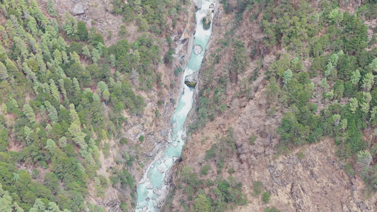 A clean Himalayan river winds through the Everest region, flanked by lush green mountains on both sides, offering a tranquil glimpse of Nepal’s natural beauty along the EBC trekking route.