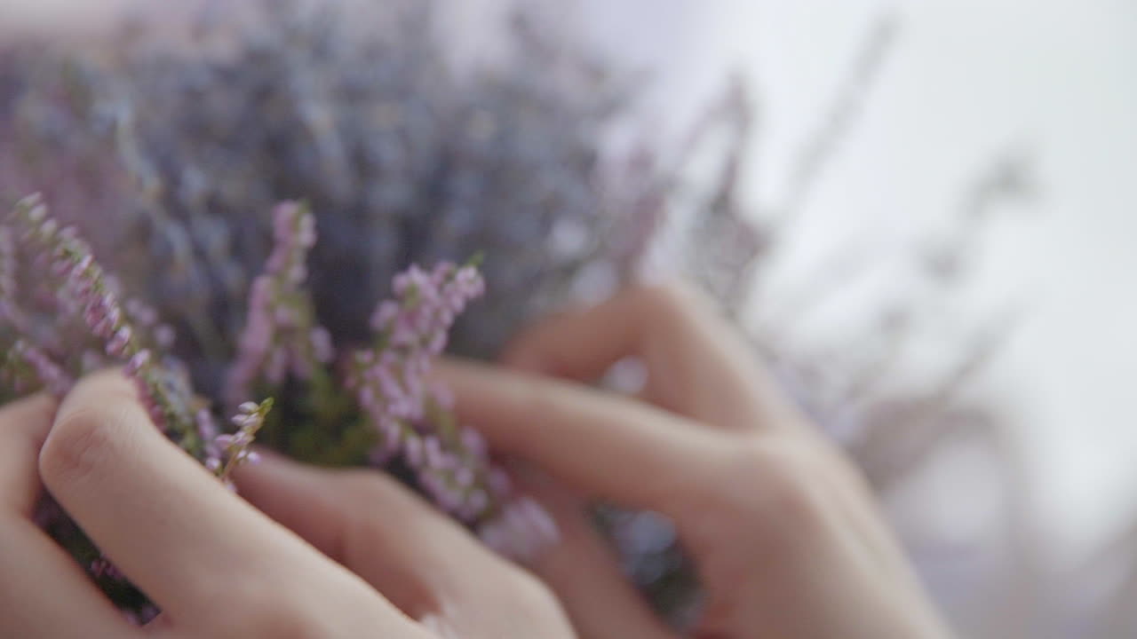 mano femenina pone un ramo de lavanda en una mesa de madera